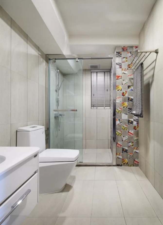 卫生间地面与墙面通铺卡其色瓷砖,在淋浴区铺贴花砖,增添一份俏皮