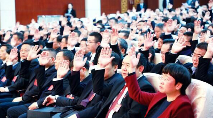 委员们举手表决相关决议.