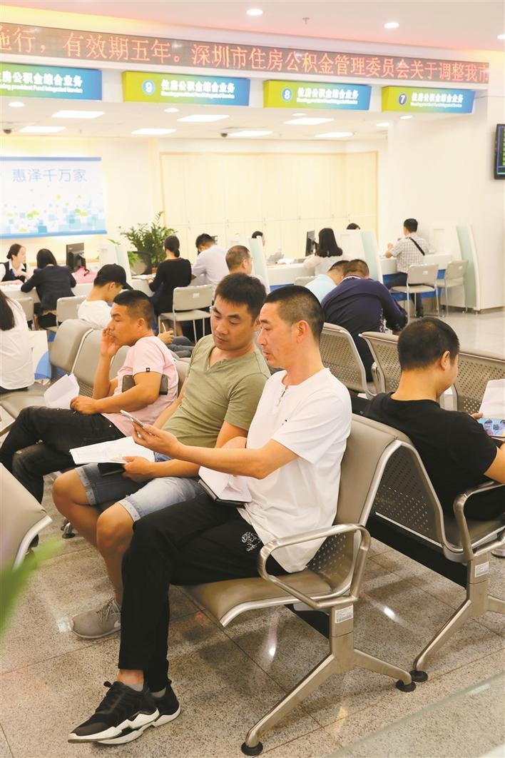 市民在深圳市住房公积金管理中心办事大厅学习用手机在网上办理业务