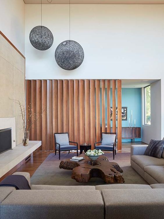 现代风格的空间,配有蜂蜜色木板屏风,将客厅与入口分隔开,防止一进入
